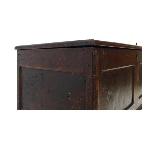 1550A - A late 17thC oak coffer with a panelled lid and sides raised on four stile feet. 42