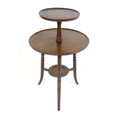 1560A - An Aesthetic movement walnut dumb waiter designed by E.W Godwin. The waiter having two dished tiers ... 