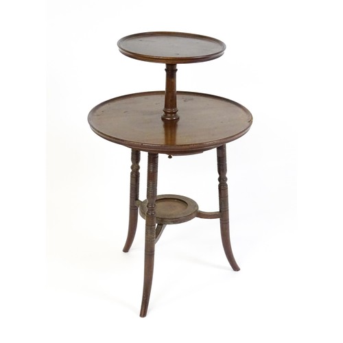 1560A - An Aesthetic movement walnut dumb waiter designed by E.W Godwin. The waiter having two dished tiers ... 