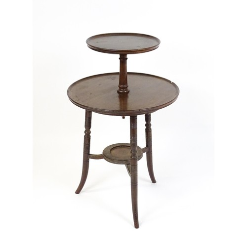 1560A - An Aesthetic movement walnut dumb waiter designed by E.W Godwin. The waiter having two dished tiers ... 