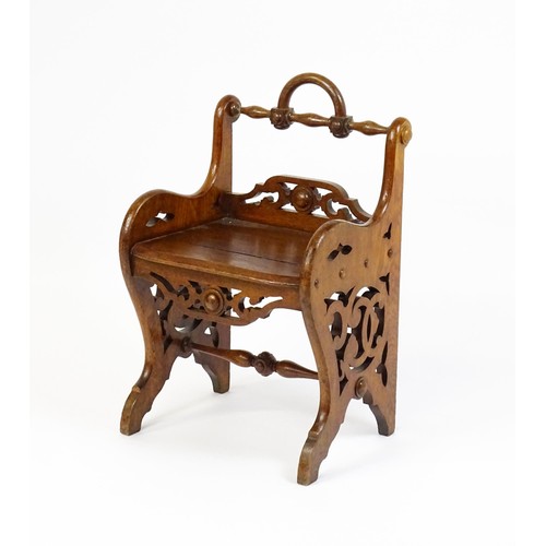 1570A - A 19thC oak Gothic hall chair with a loop handle to the top and carved roundel decoration alongside ... 