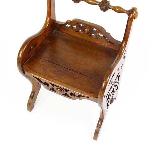 1570A - A 19thC oak Gothic hall chair with a loop handle to the top and carved roundel decoration alongside ... 