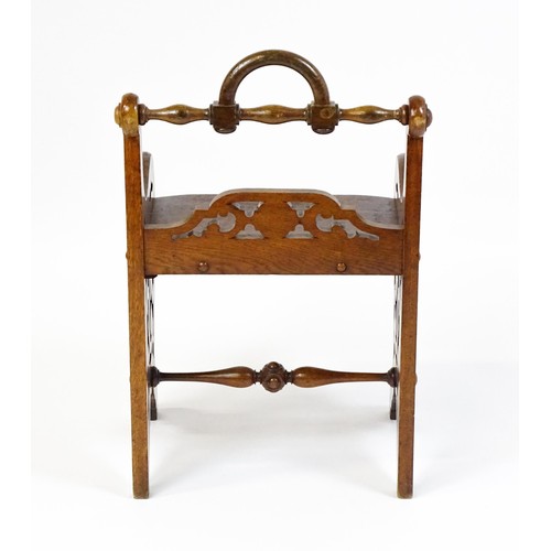 1570A - A 19thC oak Gothic hall chair with a loop handle to the top and carved roundel decoration alongside ... 