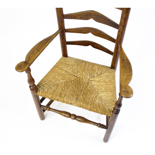 1555A - An early 19thC elm rush seated ladderback armchair, raised on turned tapering legs united by a box s... 