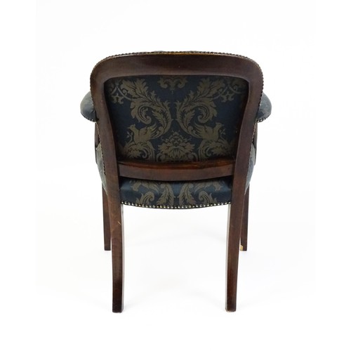 1585A - A late 19th century show wood desk chair with studded upholstery, swept arms and raised on straight ... 