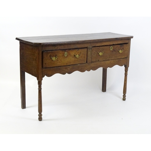 1583A - A mid / late 18thC oak Georgian dresser base with canted front corners with two short drawers having... 