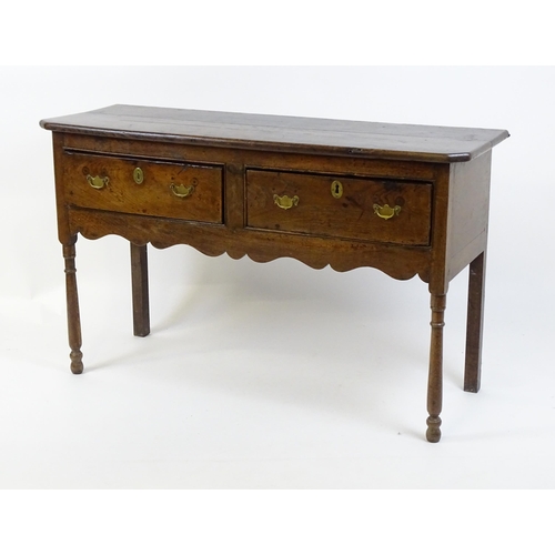 1583A - A mid / late 18thC oak Georgian dresser base with canted front corners with two short drawers having... 