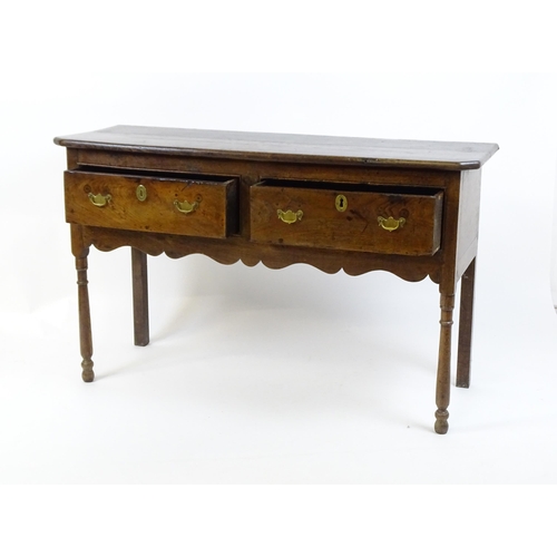 1583A - A mid / late 18thC oak Georgian dresser base with canted front corners with two short drawers having... 