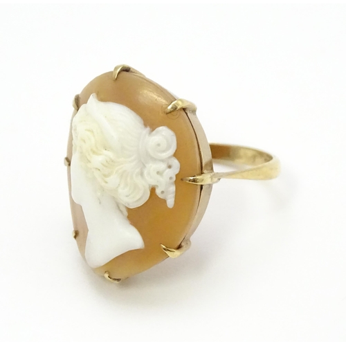 698 - A 9ct gold ring set set with central shell carved cameo. Ring size approx O