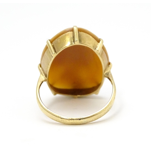 698 - A 9ct gold ring set set with central shell carved cameo. Ring size approx O