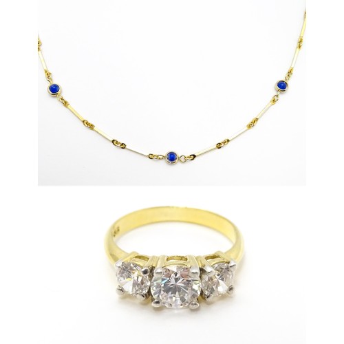 769 - A gilt metal chain necklace set with blue beads. Together with a gilt metal ring set with three whit... 