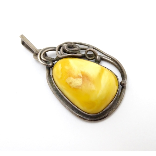 871A - Three items of jewellery to include a Polish silver pendant set with amber cabochon, a Lithuanian st... 