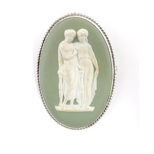 904A - A shell carved cameo brooch with white metal mount together with a brooch set with Wedgwood jasperwa... 