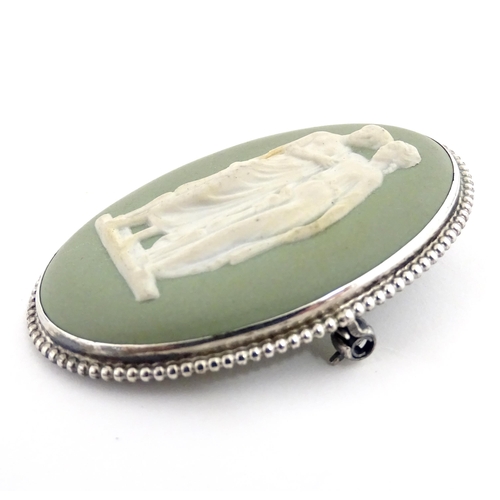 904A - A shell carved cameo brooch with white metal mount together with a brooch set with Wedgwood jasperwa... 