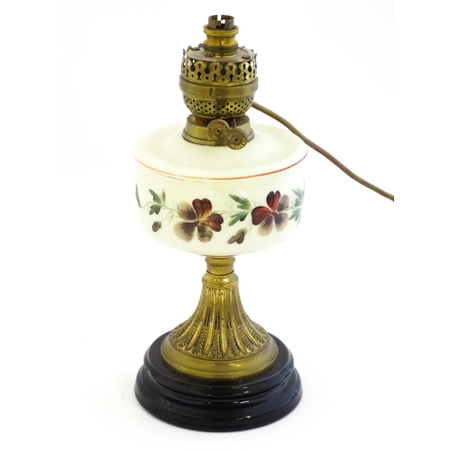 18 - A table lamp formed from an oil lamp with cream glass reservoir with hand painted flower detail. App... 