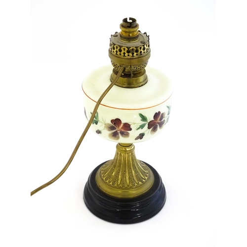 18 - A table lamp formed from an oil lamp with cream glass reservoir with hand painted flower detail. App... 