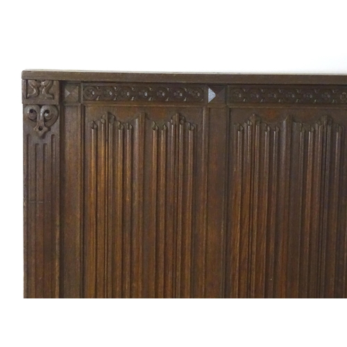 30 - An early 20thC oak panel with carved rosettes and linen fold decoration. 33