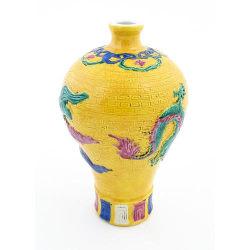 100 - A Chinese vase with relief dragon decoration and banded borders. Character marks under. Approx. 8 1/... 