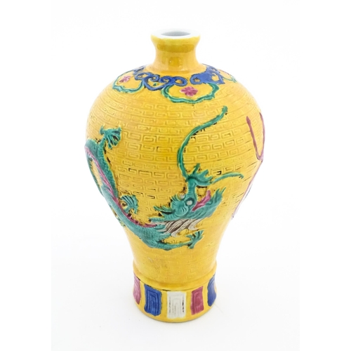 100 - A Chinese vase with relief dragon decoration and banded borders. Character marks under. Approx. 8 1/... 