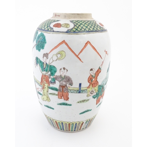 101 - A Chinese famille verte vase decorated with figures in a garden with banded borders. Approx. 11 3/4