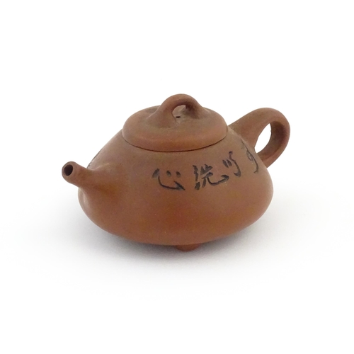 102 - A Chinese Yixing teapot with incised tree and script detail. Character marks under and to underside ... 