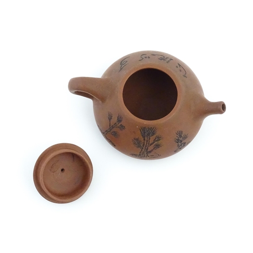 102 - A Chinese Yixing teapot with incised tree and script detail. Character marks under and to underside ... 