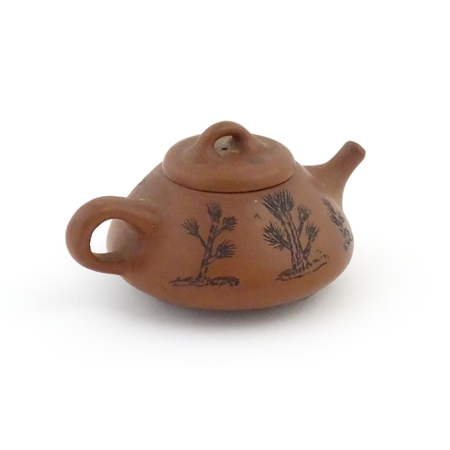 102 - A Chinese Yixing teapot with incised tree and script detail. Character marks under and to underside ... 