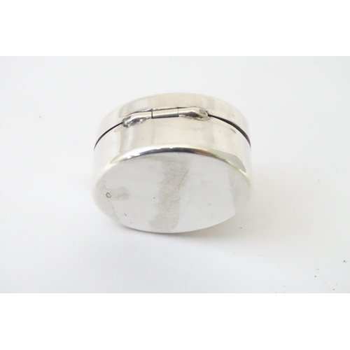 425 - A white metal pill box of oval form with hinged lid. Approx. 1 1/8