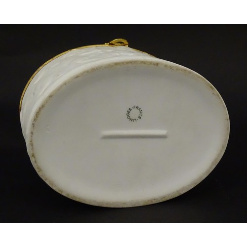 498 - A Limoges parian ware oval box with a hinged lid, decorated in relief with dancing putti / cherubs. ... 