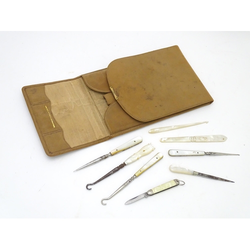 512 - A quantity of early 20thC mother of pearl / mother of pearl handled tools to include button hooks, s... 