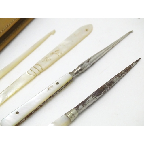 512 - A quantity of early 20thC mother of pearl / mother of pearl handled tools to include button hooks, s... 