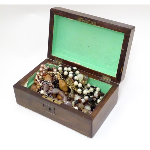 526 - A box containing an quantity of assorted jewellery to include brooches, beads etc.