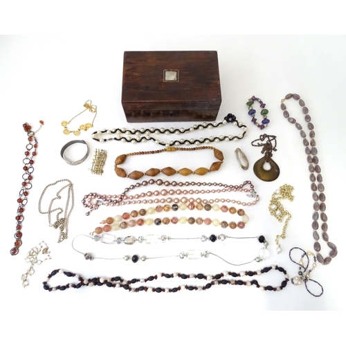 526 - A box containing an quantity of assorted jewellery to include brooches, beads etc.