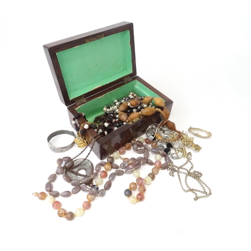 526 - A box containing an quantity of assorted jewellery to include brooches, beads etc.