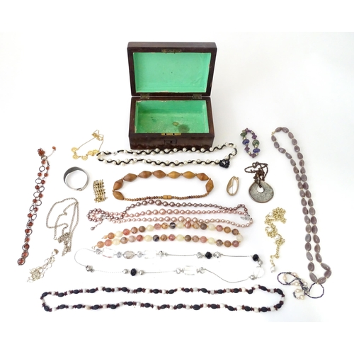 526 - A box containing an quantity of assorted jewellery to include brooches, beads etc.