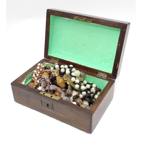 526 - A box containing an quantity of assorted jewellery to include brooches, beads etc.