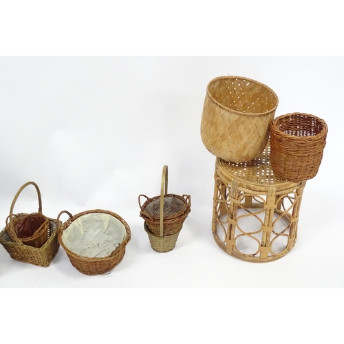 586 - A bamboo and rattan circular table together with a collection of wicker baskets, etc.