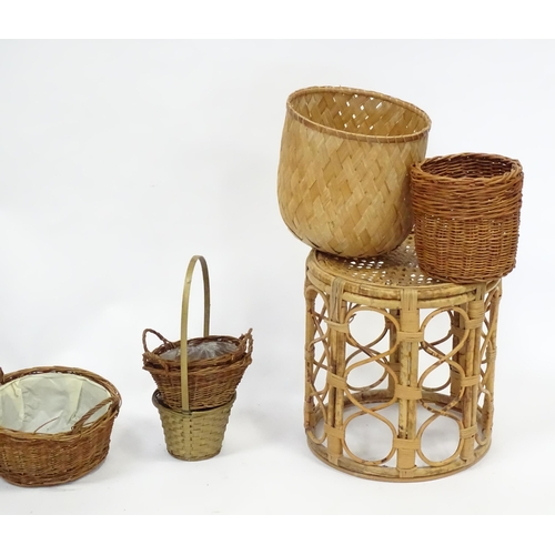 586 - A bamboo and rattan circular table together with a collection of wicker baskets, etc.