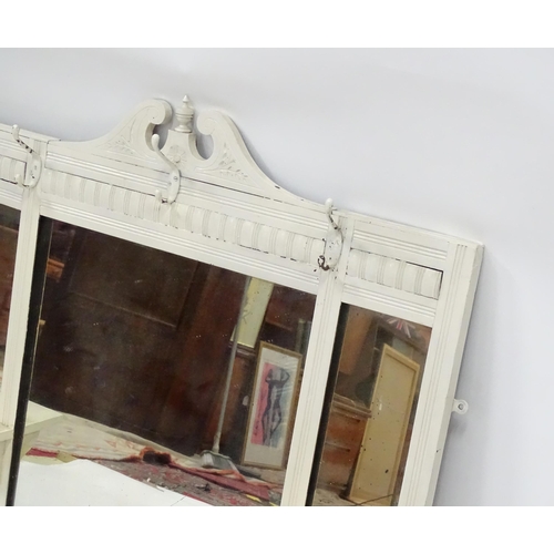 606 - An Edwardian painted mirror with a carved pediment and two shelves. 44