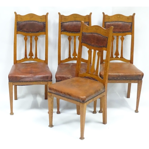 908 - Four Art Nouveau oak dining chairs, with flower formed back splats, inlaid backrests, leather back r... 