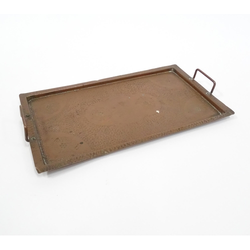 120 - A 20thC copper tray of rectangular form with twin handles and hammered decoration. Approx. 20 1/4