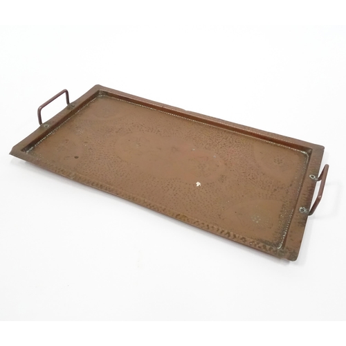 120 - A 20thC copper tray of rectangular form with twin handles and hammered decoration. Approx. 20 1/4