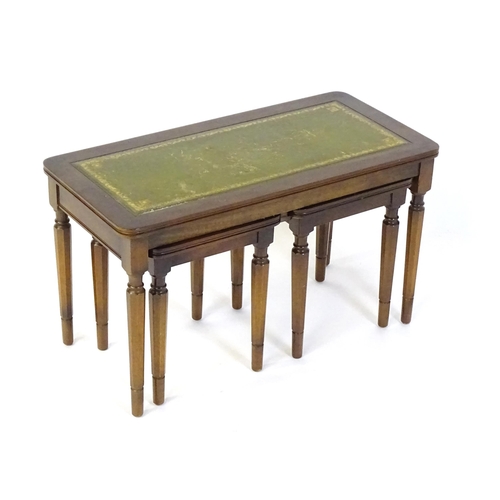 182 - A nest of three tables with gold tooled green leather tops. The largest measuring 30