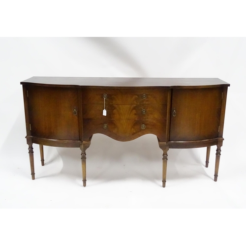 183 - A 20thC mahogany sideboard with shaped front,  comprising two cupboards with shelves and opposing do... 