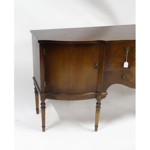 183 - A 20thC mahogany sideboard with shaped front,  comprising two cupboards with shelves and opposing do... 