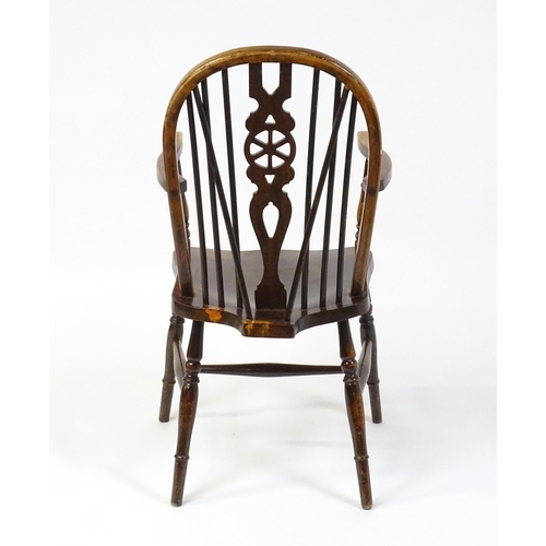 189 - An early 20thC wheel back Windsor chair, having a shaped seat and raised on turned tapering legs uni... 