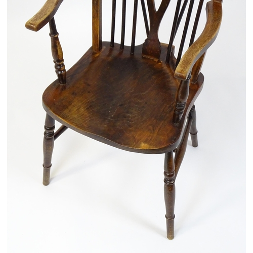 189 - An early 20thC wheel back Windsor chair, having a shaped seat and raised on turned tapering legs uni... 