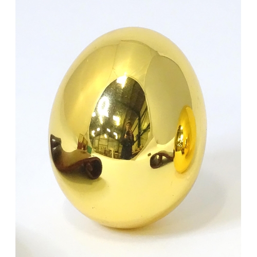 257 - Two Risis models of eggs covered in 999 gold with wooden stands and boxed. (2)