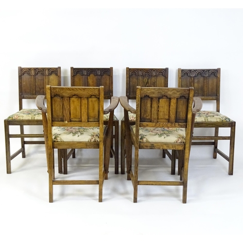 28 - A set of six early / mid 20thC oak and elm Gothic Ercol style dining chairs. The armchairs measuring... 