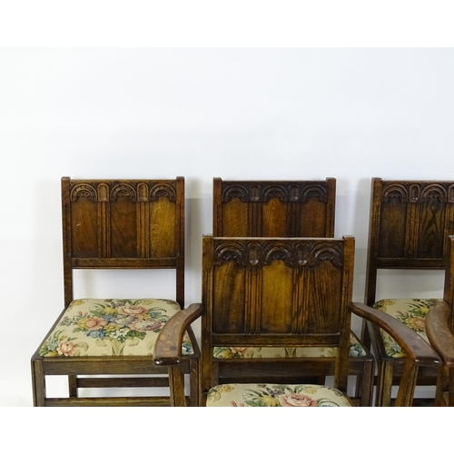 28 - A set of six early / mid 20thC oak and elm Gothic Ercol style dining chairs. The armchairs measuring... 